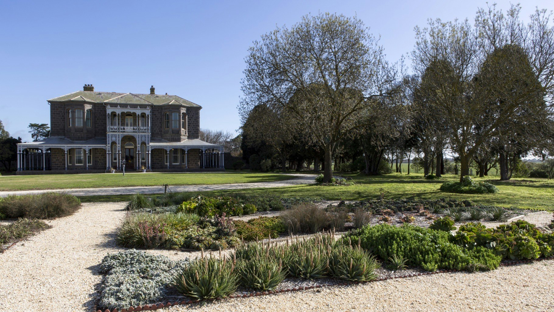 Garden beds with estate in background.
